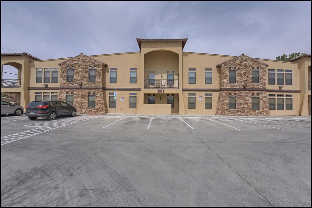 an empty parking lot in front of an apartment building