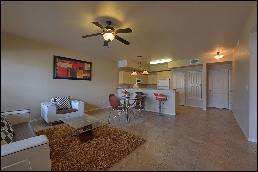 a living room and a kitchen with a ceiling fan
