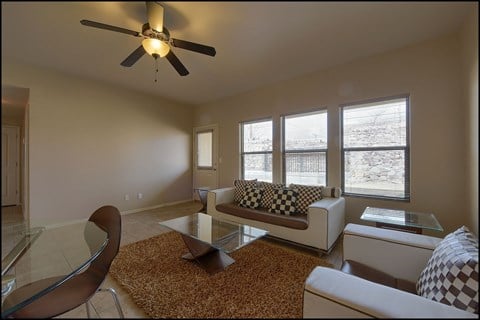 A living room with a brown rug and a white couch.