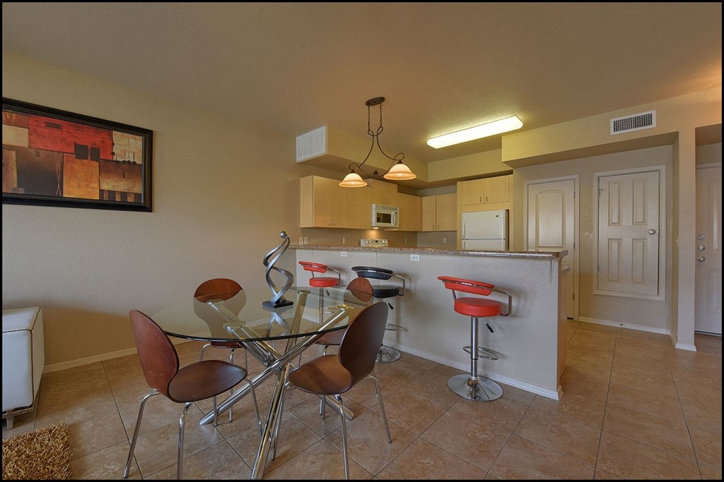 a dining room with a glass table and chairs