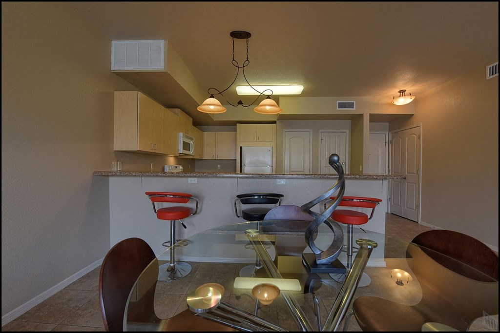 a dining room with a glass table and chairs