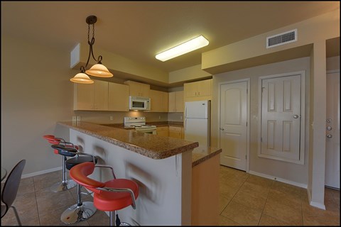 A kitchen with a counter and bar stools.