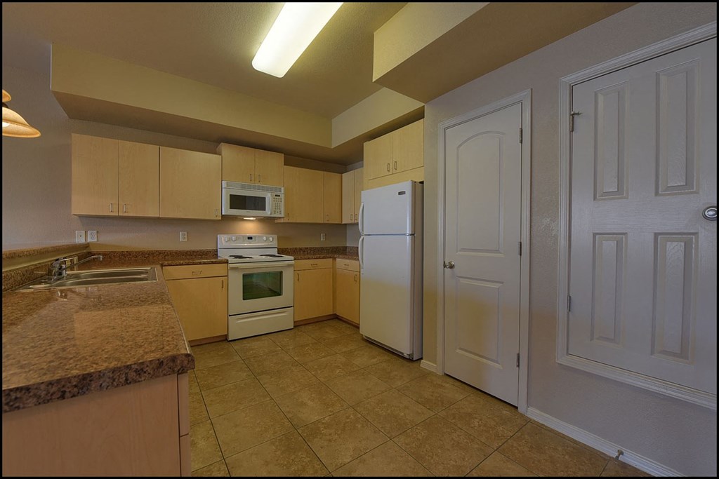 a kitchen with a white refrigerator and a sink