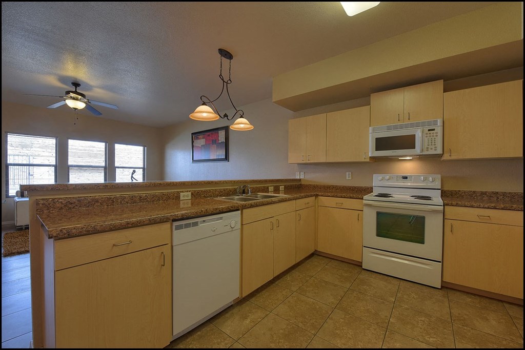 a kitchen with white appliances and granite counter tops