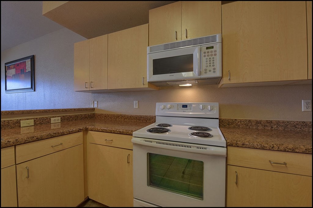 a kitchen with a white stove and a microwave