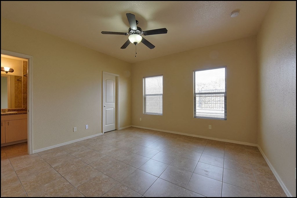 a empty living room with a ceiling fan