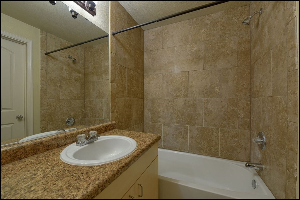 a bathroom with a sink and a tub and a shower