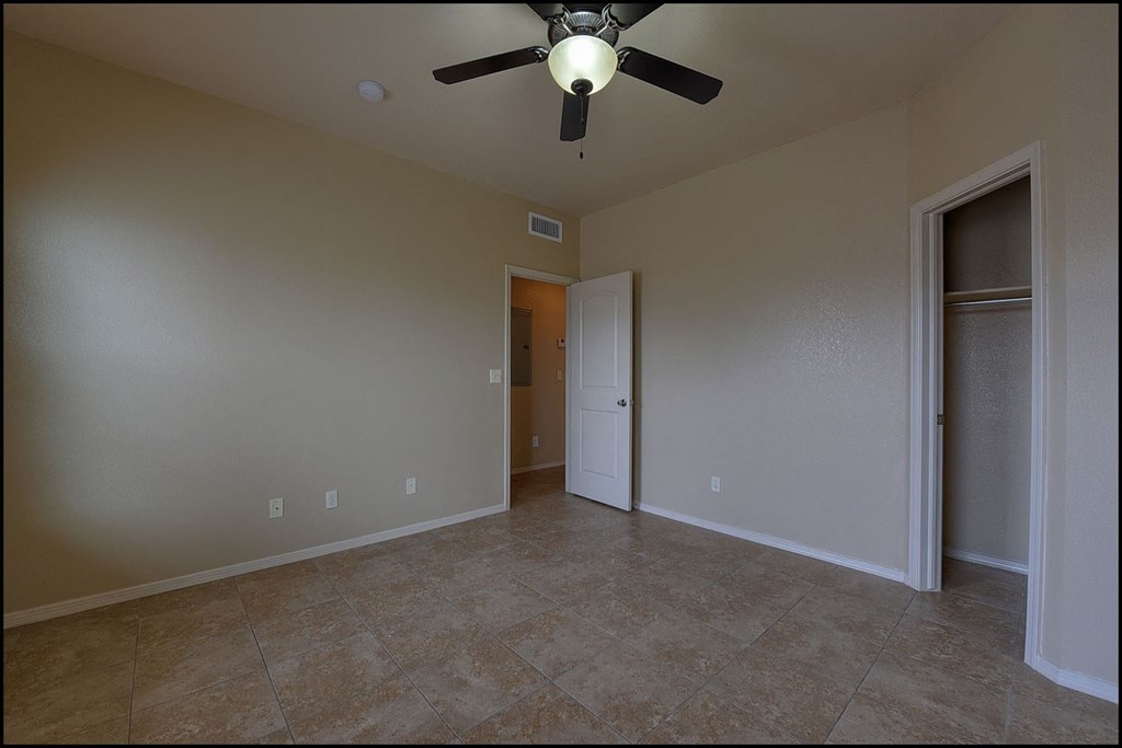 a empty living room with a ceiling fan