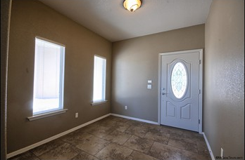 a empty room with a door and two windows