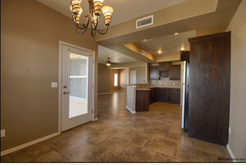 a large kitchen with a door to the living room