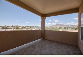 a balcony with a view of the desert and a blue sky