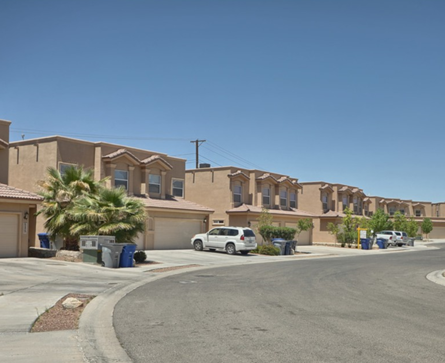 a street in a subdivision with houses and a car parked in front