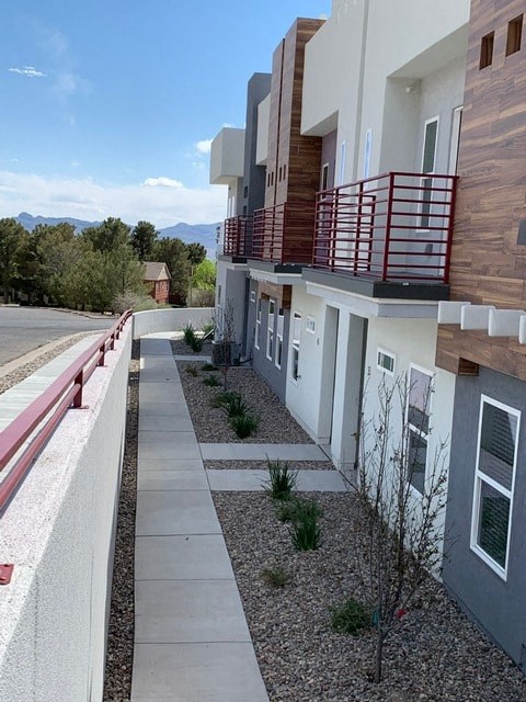 a building with a balcony and a sidewalk next to a street