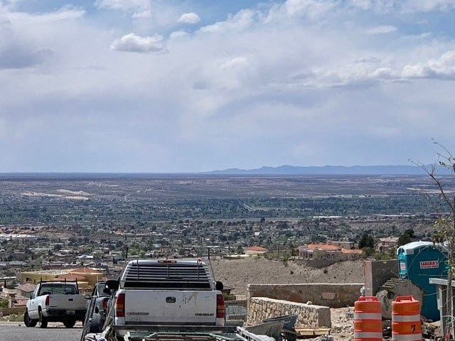 a truck parked on the side of a hill overlooking a city