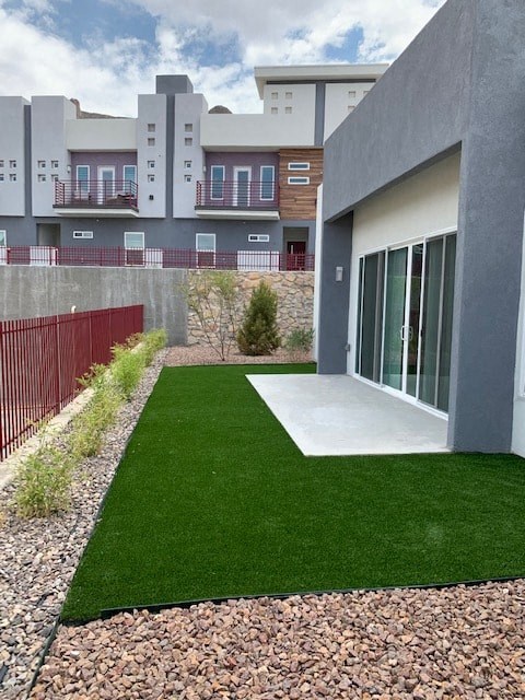 a yard in front of a building with artificial grass