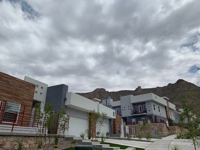 a group of buildings with mountains in the background