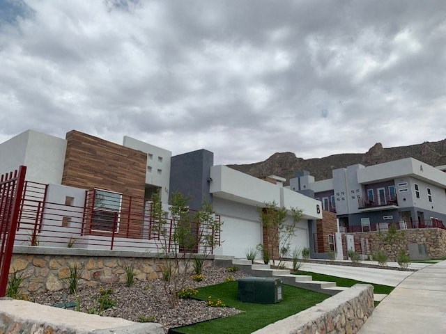 a group of houses with a courtyard and a cloudy sky