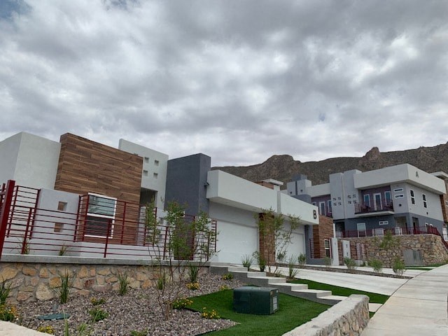 a group of modern buildings with mountains in the background