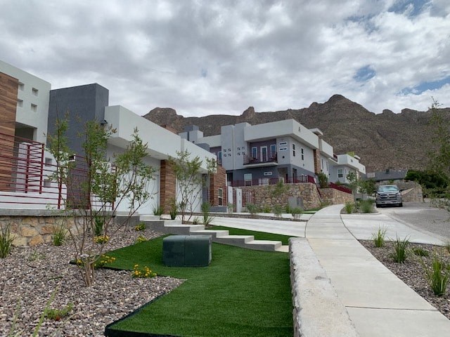 a row of houses with green grass and a sidewalk