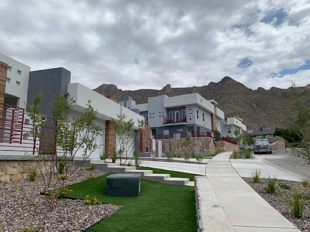a row of houses with a sidewalk and grass