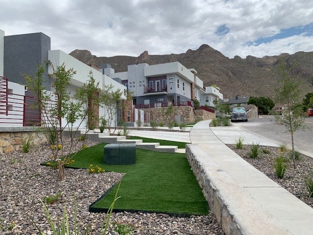 a row of houses with green grass and a sidewalk