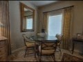 A dining room with a table and chairs.