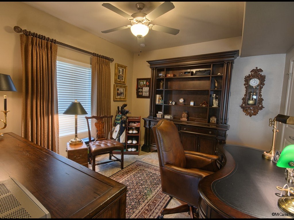 A room with a brown leather chair and a wooden desk.