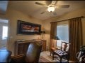 A living room with a brown leather couch and a painting on the wall.