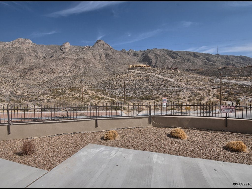 A concrete patio with a mountain in the background.