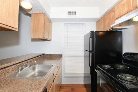 A black stove top oven sits next to a sink in a kitchen.