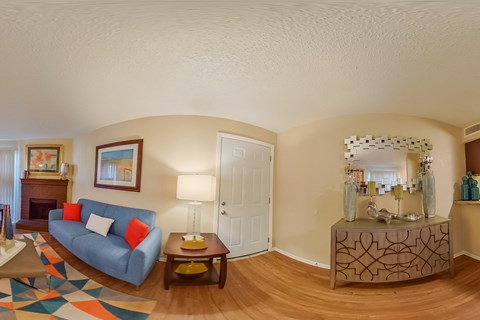 A living room with a blue couch and a wooden coffee table.