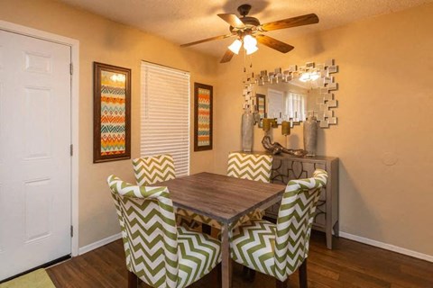 A dining room with a wooden table and chairs with chevron patterned covers.