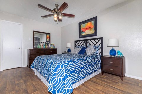 A bedroom with a blue and white patterned bedspread.