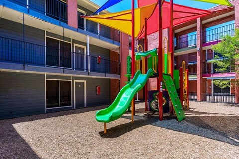 A brightly colored playground slide in front of a building.