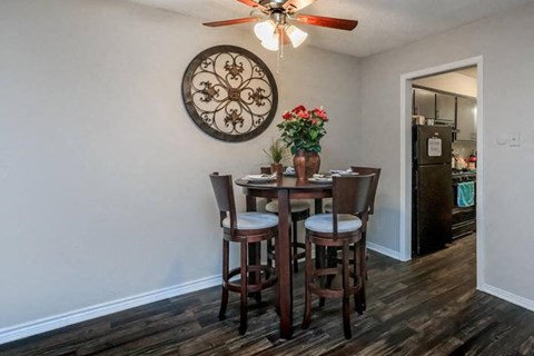 A dining room with a wooden table and chairs.