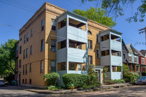 A building with a yellow and blue facade is situated on a street corner.