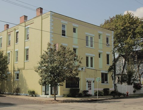 a large yellow house on the corner of a street