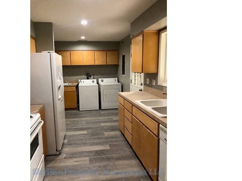 a kitchen with white appliances and wooden cabinets