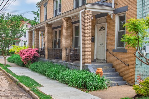 A brick house with a white door and windows.