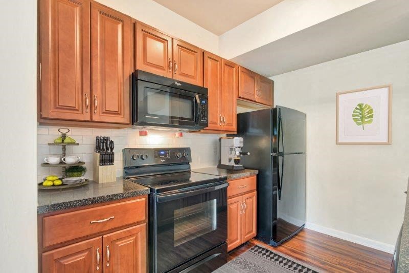 a kitchen with black appliances and wooden cabinets