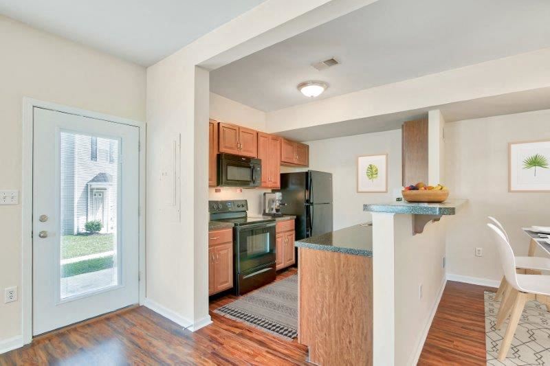 an empty kitchen with a door to the living room