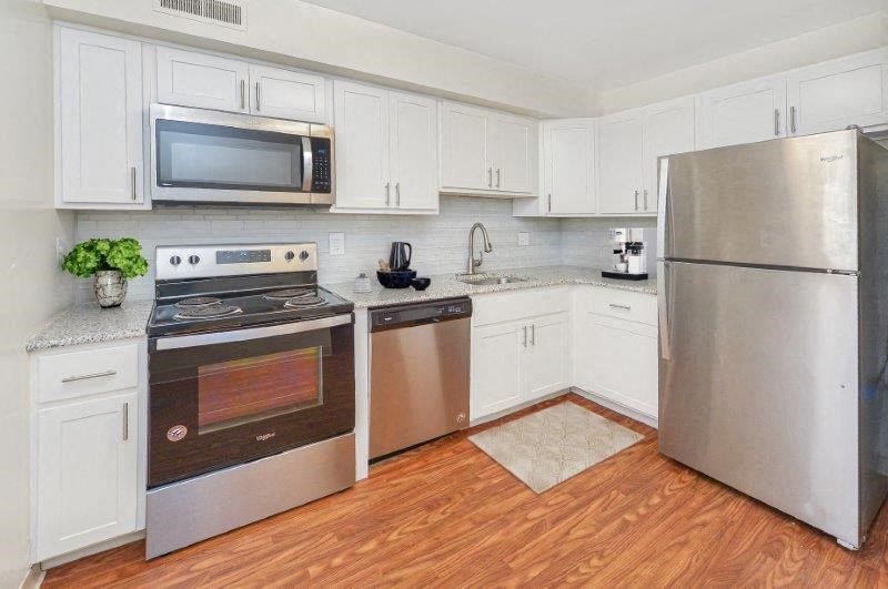 a kitchen with stainless steel appliances and white cabinets