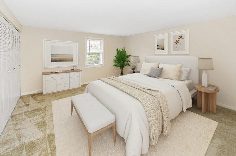 a white bedroom with a bed and a table