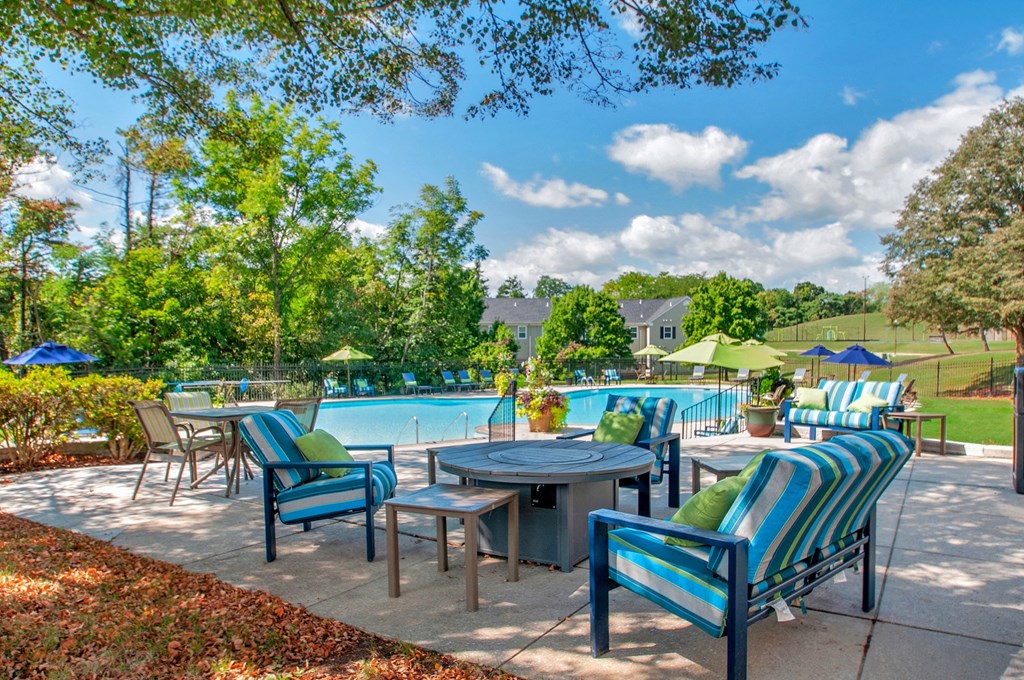 an outdoor patio with tables and chairs near a swimming pool
