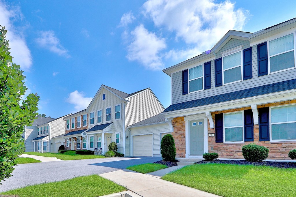 a row of houses on a street with grass