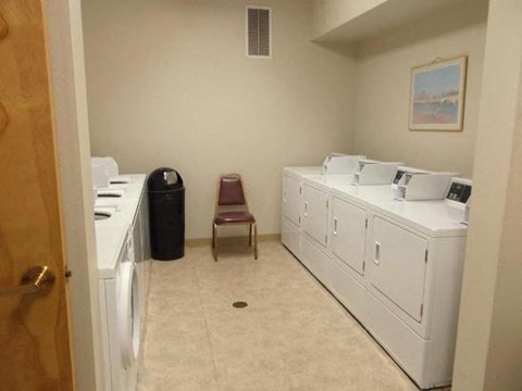 a laundry room with two washing machines and a chair