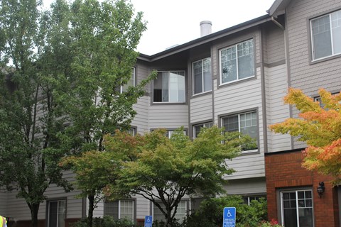 an apartment building with trees in front of it