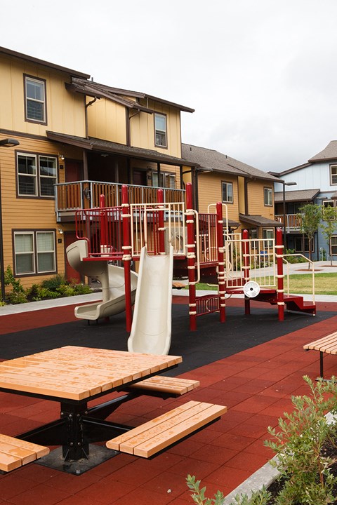 a playground is shown in front of an apartment building
