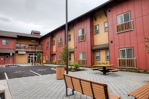a courtyard with benches and a table outside of a building