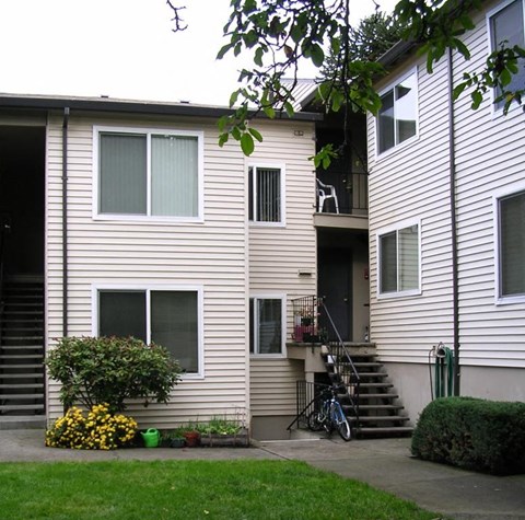 A two-story house with a bicycle leaning against the wall.